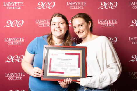 Two women are holding a framed award