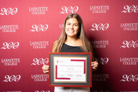 Grace Vale '27 is holding a framed award.