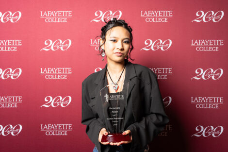 Isabella Mascarinas ’28 is holding a glass award.