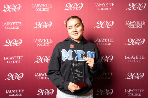 Jaylene Martinez ’26 is holding a glass award.