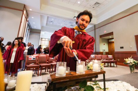 A student lights a candle at Unidos en Celebración