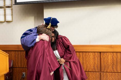 Two students hug Trent Gaugler at Posse Celebration
