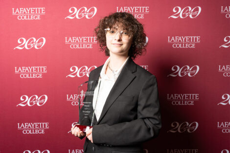 Tim Jarkow ’27 is holding a glass award.