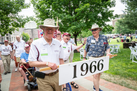 Members of the Class of 1966 walk in the parade with the 1966 sign.