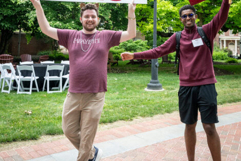 Two alumni hold up a Lafayette College sign and a 2025 sign.
