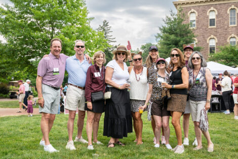 A group of alumni stand on the Quad.
