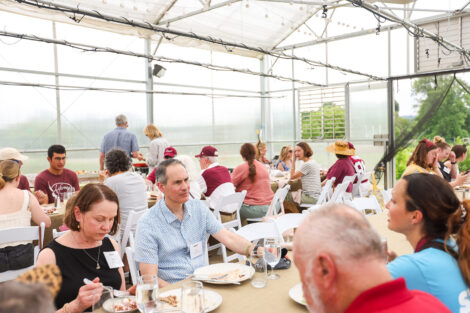 Alumni have lunch in the greenhouse at LaFarm.