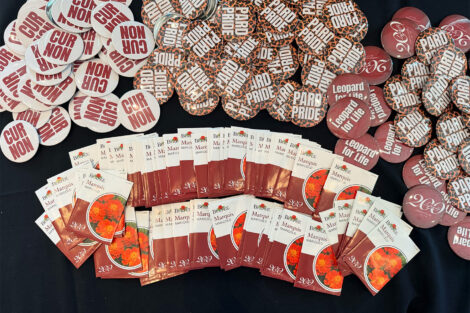 Burpee seed packets and buttons are on display on a table.