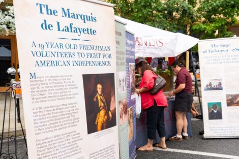 Several panels stand outside detailing the life and history of the Marquis de Lafayette as visitors explore the Lafayette table.