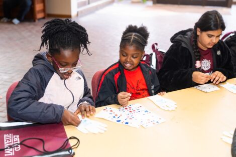 3 Easton fourth graders add stickers to white gloves.