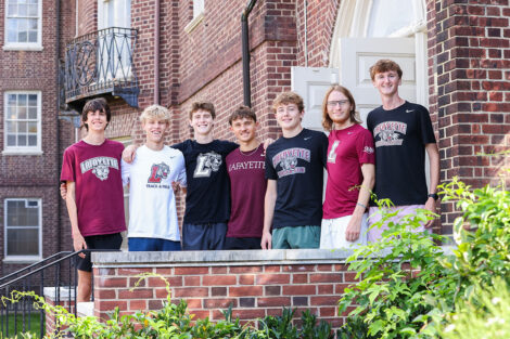 Students smile outside their residence hall during move-in day.