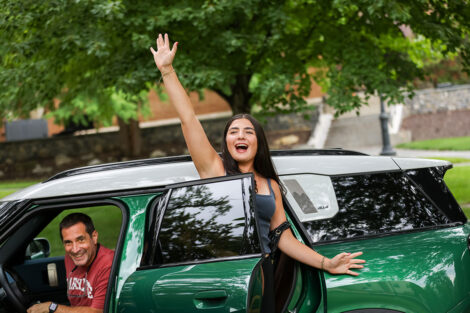 A student exits the car to begin to unpack.