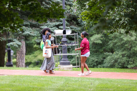 Students help each other carry a shelf across campus.
