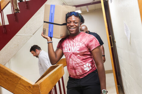 A student carries a back to its final destination on move-in day.
