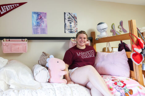 A student shows off her residence hall room after unpacking.