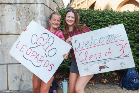 Two students display their signs and school spirit on Move-in day.