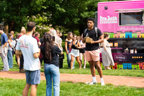 A student poses for a photo in front of a food truck.